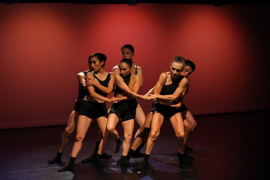Dynamic group of dancers performing contemporary choreography under stage lights
