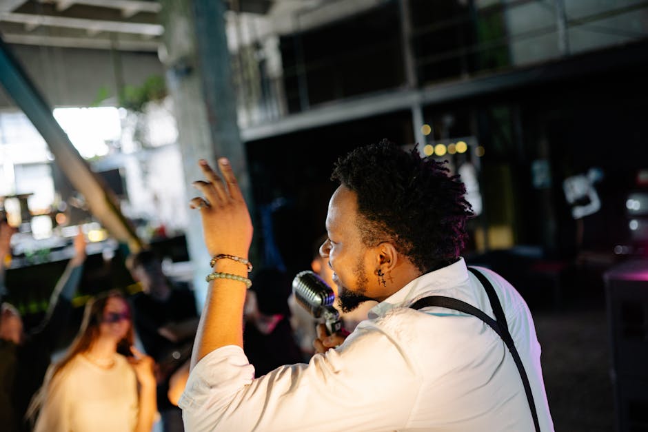 A male musician passionately performing on stage with a vibrant audience
